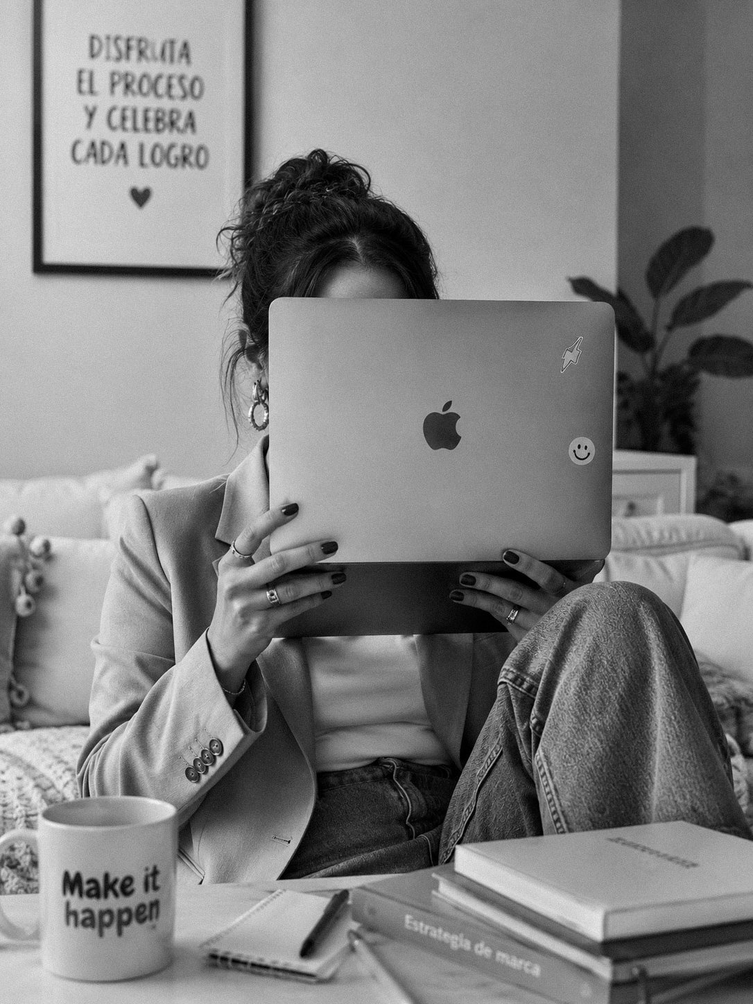 Creativa sosteniendo una MacBook frente a su rostro